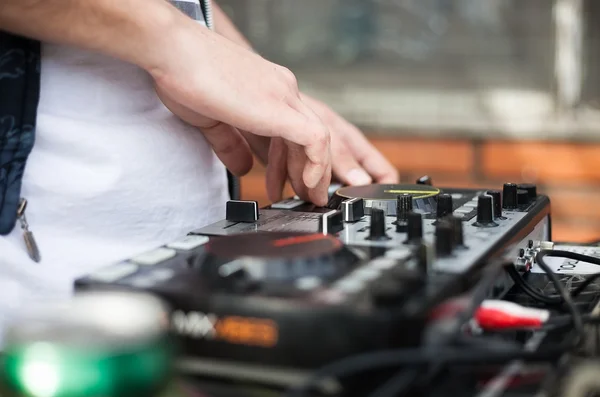 Disc jockey mixing music tracks on midi controller turntable