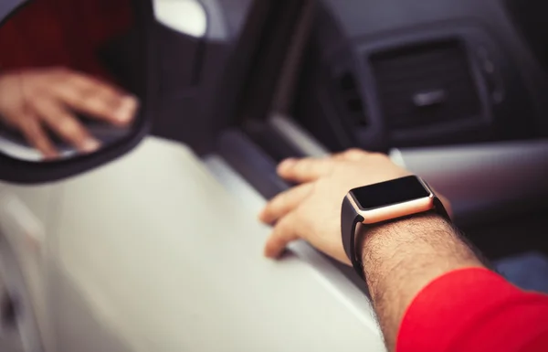 Hand of black man wearing smart watch sitting in car