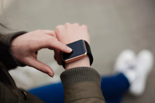 Woman using her smart watch on hand
