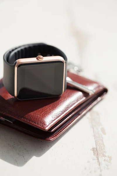 Smart watches, keys and brown leather wallet