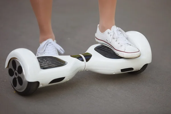 Feet of girl riding electric mini hoverboard scooter
