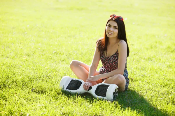 Girl with electric mini hover board scooter in park