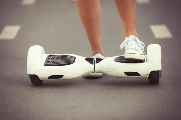 Feet of girl riding electric mini hoverboard scooter