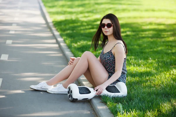 Girl with electric mini hover board scooter in park