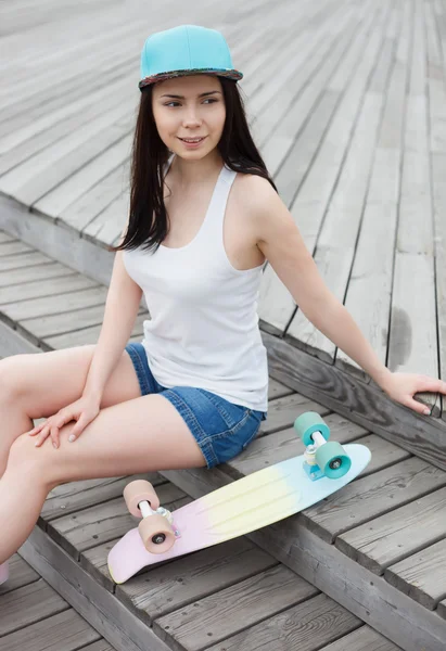 Young girl with short cruiser skateboard deck outdoors