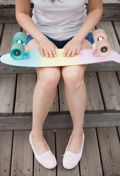Legs of girl with colorful short cruiser skateboard