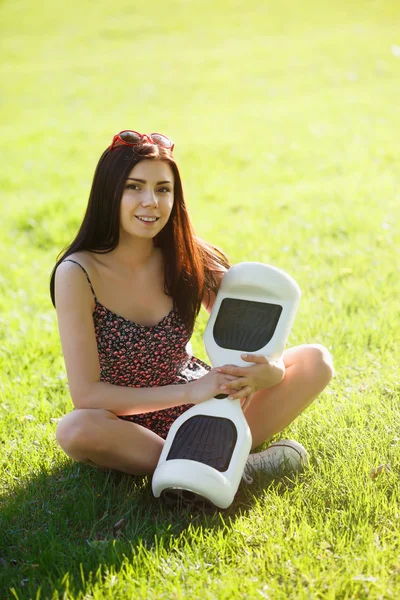 Girl with electric mini hover board scooter in park