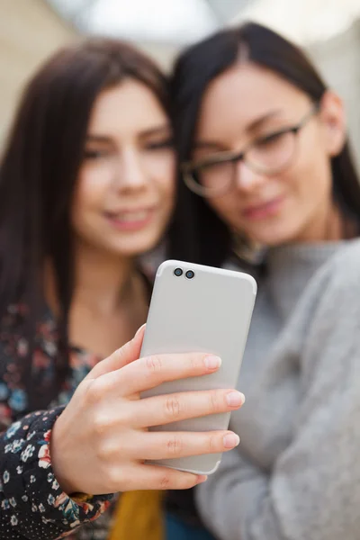 Girl taking selfie on smart mobile phone with dual camera