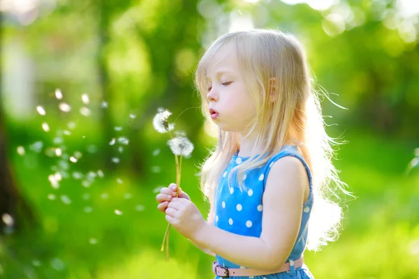 Little girl blowing off a dandelion