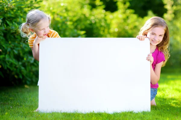 Sisters holding blank whiteboard