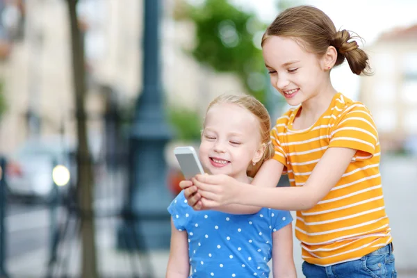 Sisters playing on smart phone