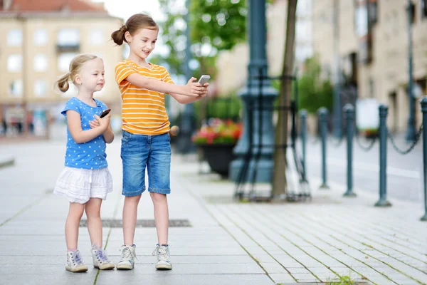 Sisters playing outdoor mobile game