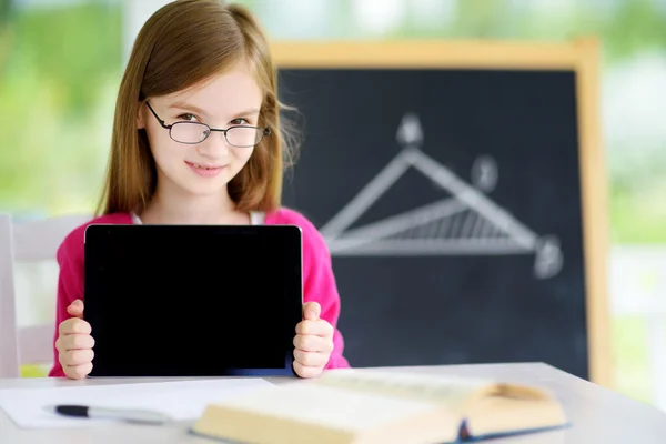Smart little schoolgirl with digital tablet
