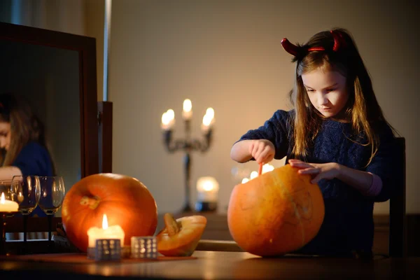 Adorable little girl with carved pumpkin