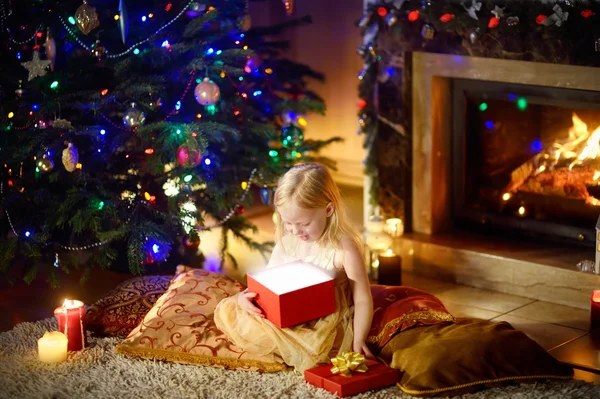 Happy girl opening Christmas gifts