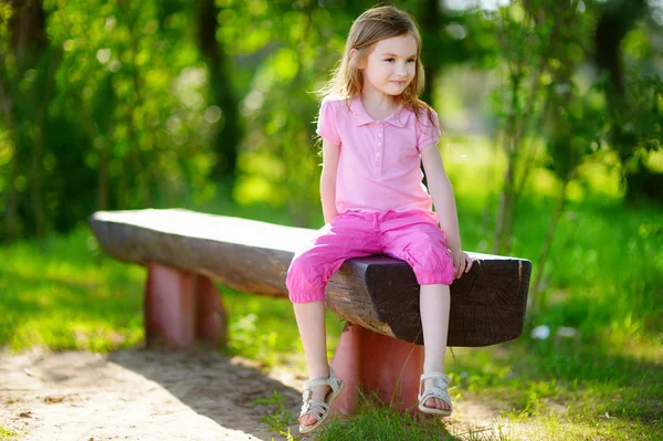 Little girl sitting on a bench