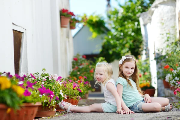 Sisters sitting among flowers