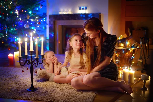 Mother and daughters near fireplace