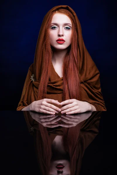 Young woman with ginger hair and scarf over reflection mirror on
