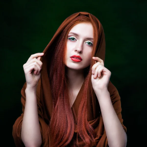 Young woman with ginger hair and scarf on green background