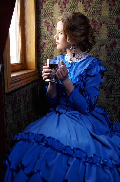 Young woman in blue vintage dress  sitting in coupe of retro rai