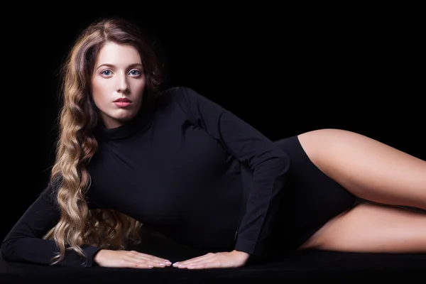 Portrait of beautiful caucasian model posing on black cloth on b