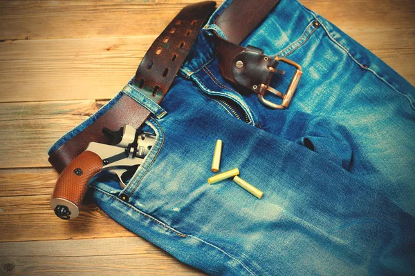 Old blue jeans with silver revolver in his pocket