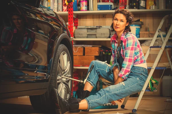 Woman mechanic prepares a car for a travel