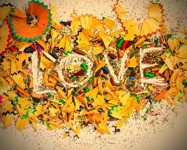 The word Love on colored pencil shavings