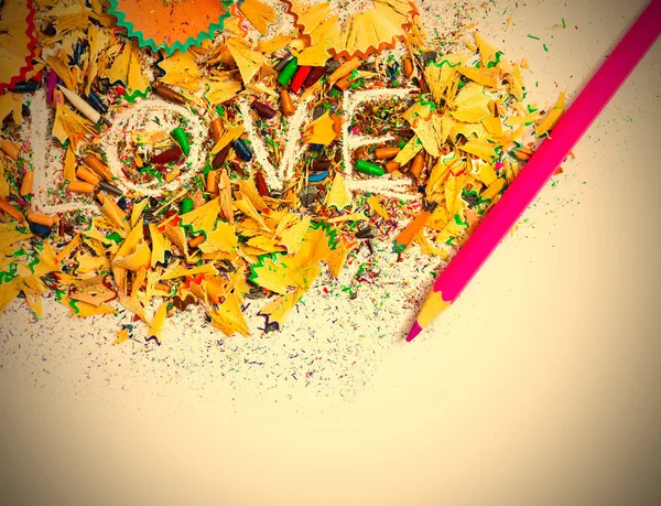 The word Love on colored pencil shavings