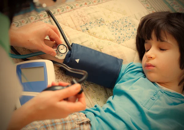 Family doctor measures the blood pressure