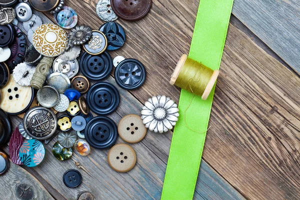 Vintage buttons, spool with thread and green tape