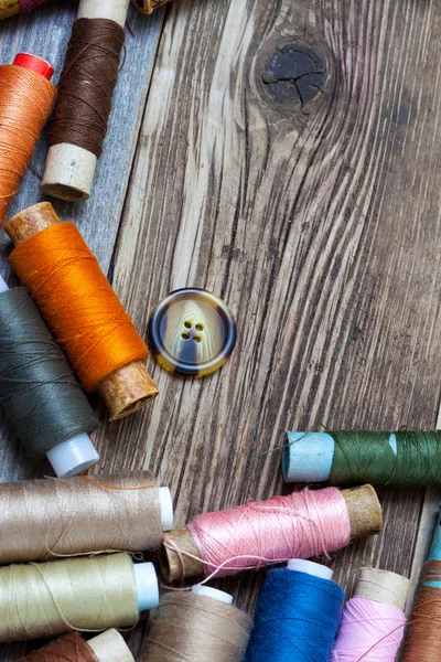 Vintage spools with multi colored threads and old button