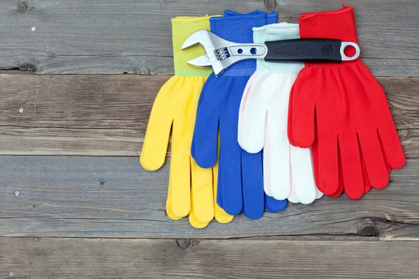 Varicolored workers gloves and wrench