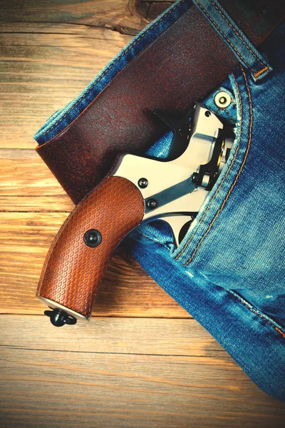 Silver revolver nagant with brown handle in the pocket