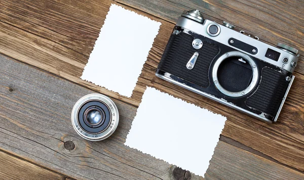 Retro photo mock up, vintage camera and lens on old wooden backg