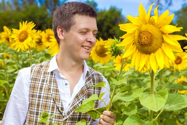 Funny man in checkered vest with the sunflower in the hand.