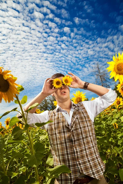 Funny man in checkered vest with the sunflower binocular