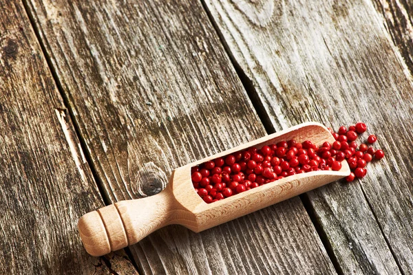 Wooden scoop with rose peppers