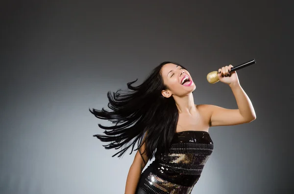 Young woman singing in karaoke club