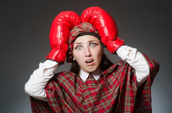 Woman in scottish clothing in boxing concept