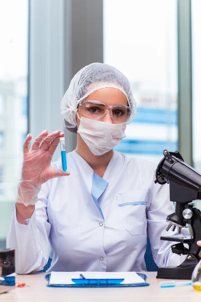 Young student working with chemical solutions in lab