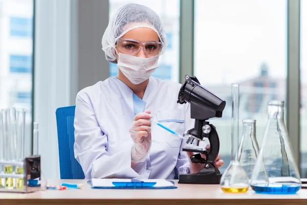 Young student working with chemical solutions in lab