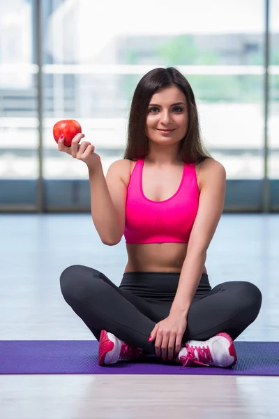 Young woman eating red apple in health concept