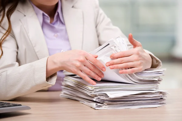 Businesswoman working with stack of papers