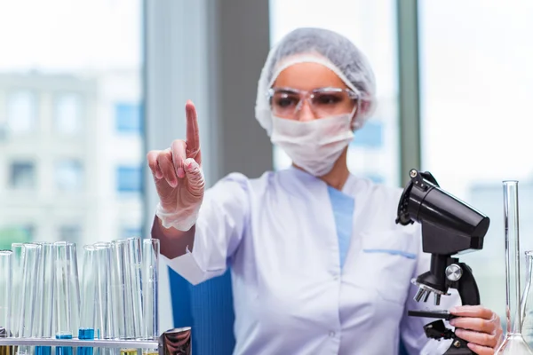 Young student working with chemical solutions in lab