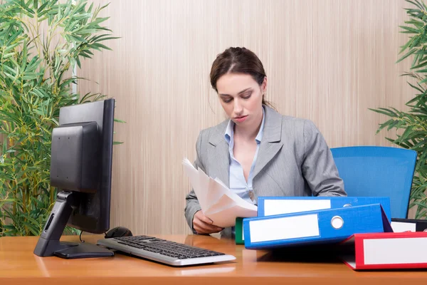 Busy businesswoman in the office under stress