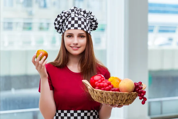 Young cook with fruits in the kitchen