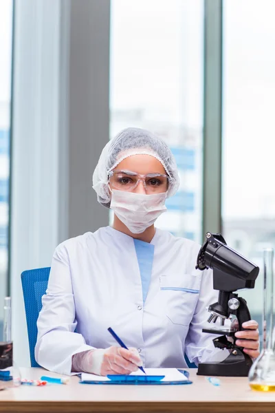 Young student working with chemical solutions in lab