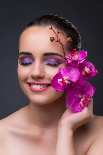 Young beautiful woman with orchid flower